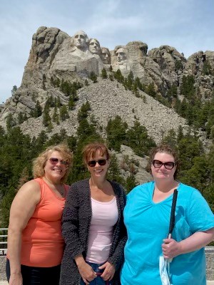 Above, Amy (far right) at Mount Rushmore with her friends/colleagues Tracy Wicken and Lori Mattick.