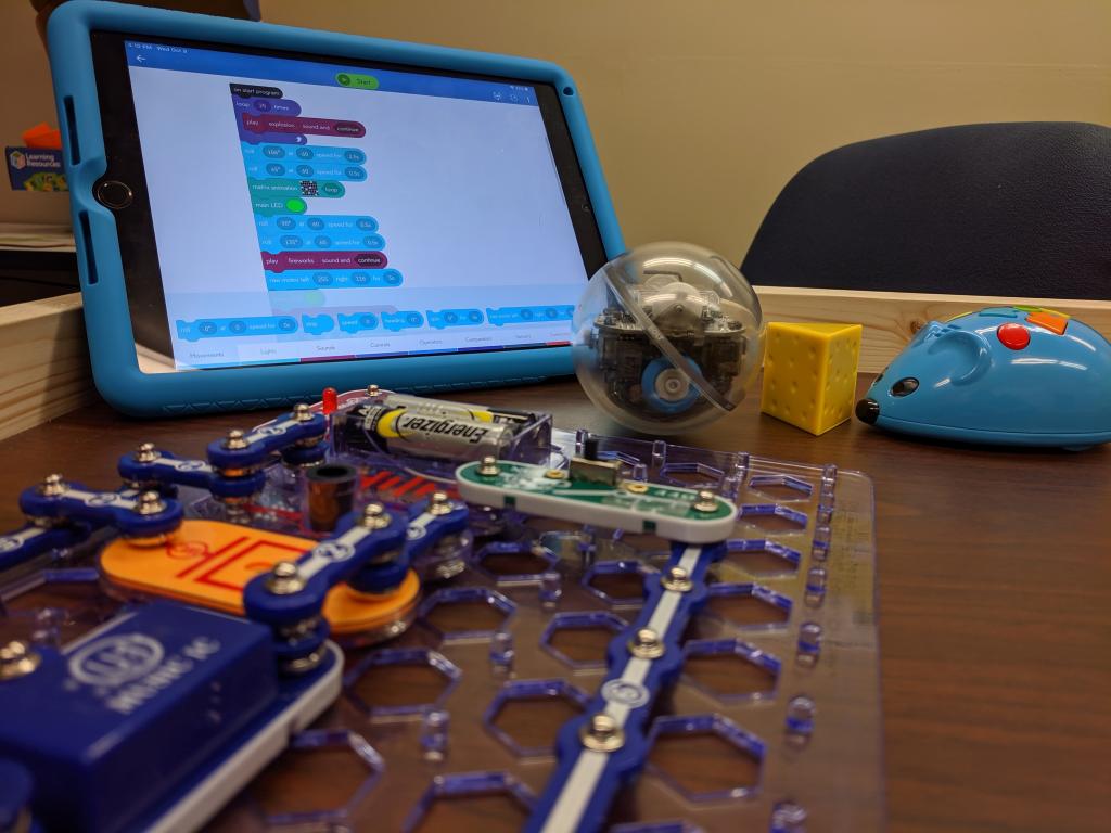 A picture of Code to Go Mouse, Ipad with Sphero Coding Application open, the Sphero Programmable Ball, and SnapCircuits with a series of connections