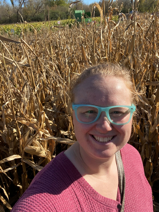 Sky smiles standing in a corn field.