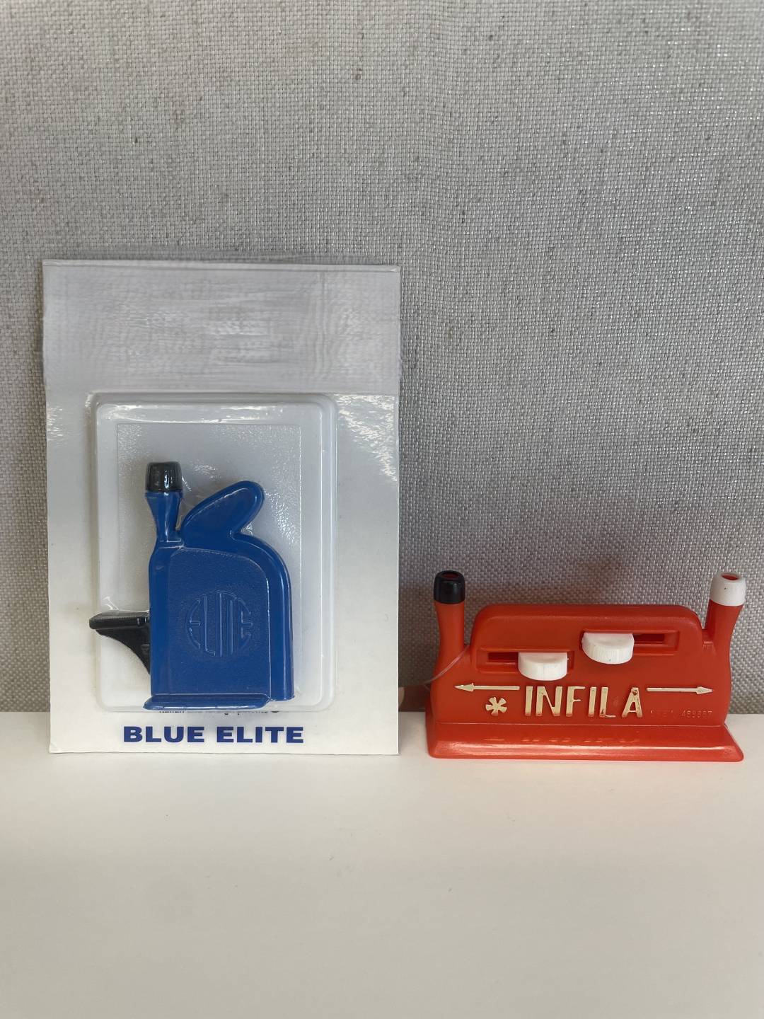 Needle Threaders, Hexe threader is vertical with black lever and notch at the top, Infila threader is horizontal with a notch on each side and two slides in the middle