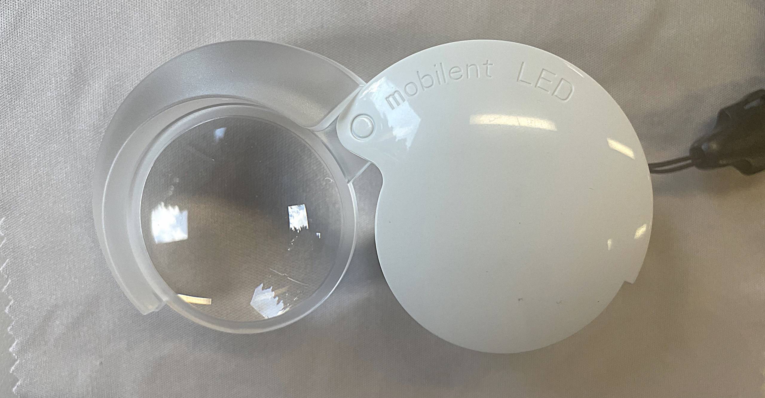 clear round lens that slides into a round white case