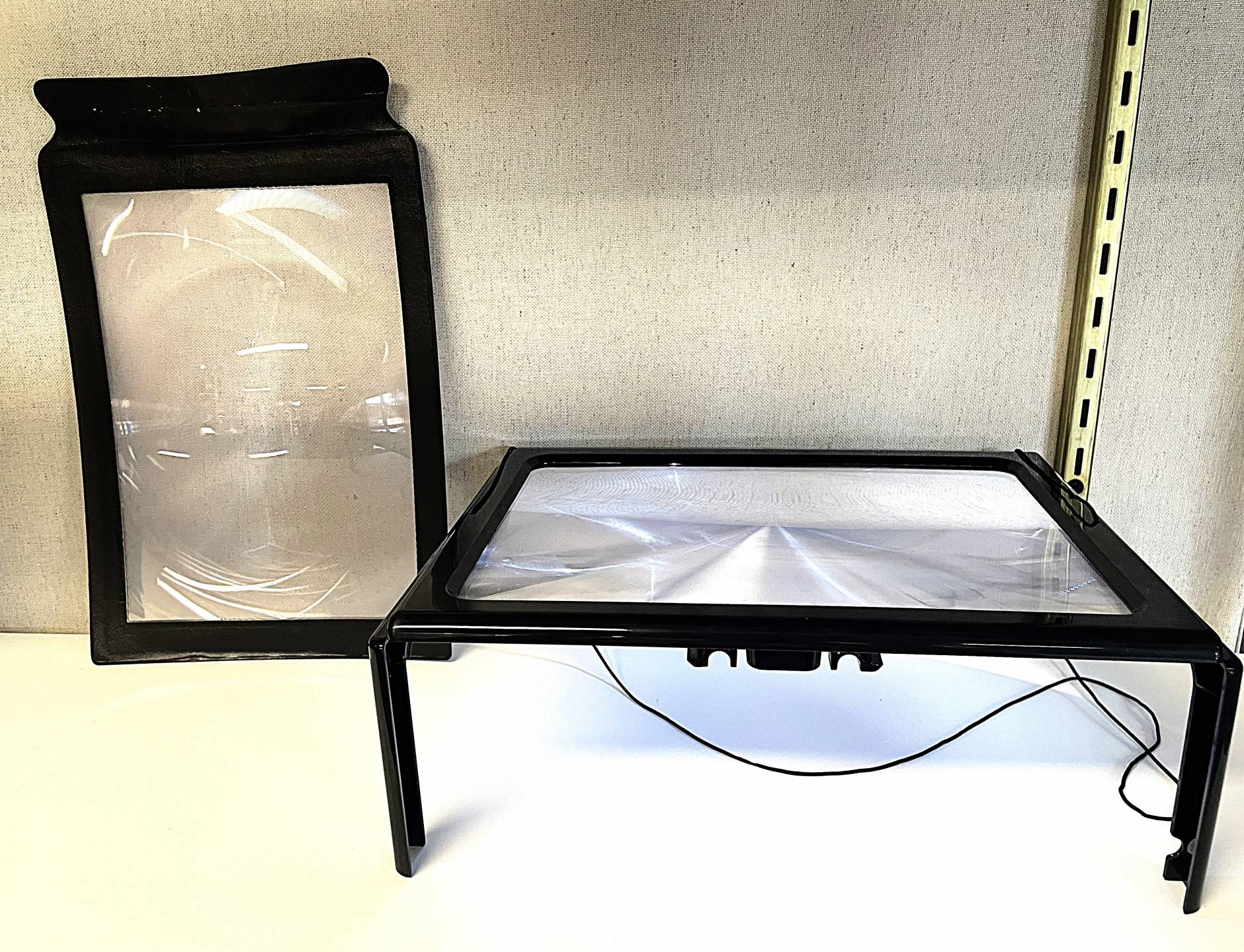 8.5 by 11 inch sheet magnifier with black border, 8.5 by 11 inch sheet magnifier on black plastic stand with 4 legs and illumination