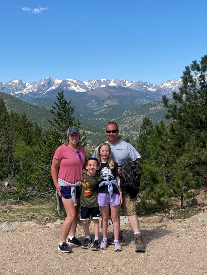 Danielle poses with her daughter, son, and husband in front of a mountain.