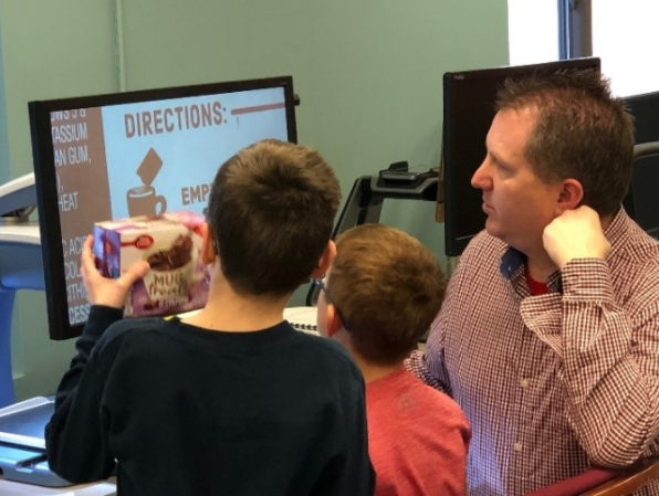 Ken working with 2 student and a video magnifier enlarging muffin mix.